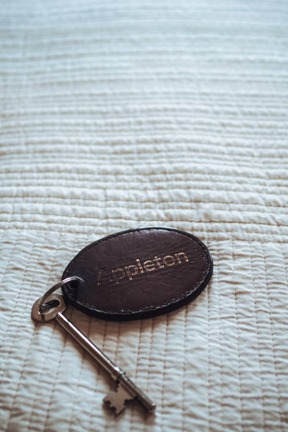 Door key on a leather keyring reading 'Appleton'