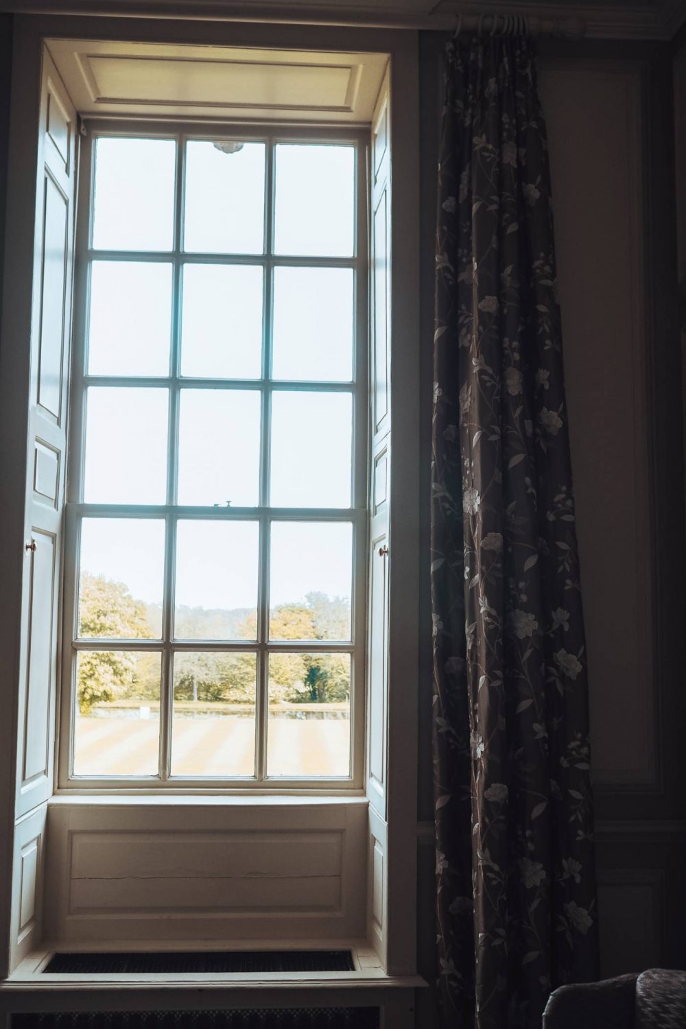 Window surrounded by floral curtains