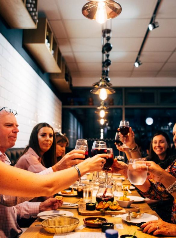 A group of people doing 'cheers' with their drinks