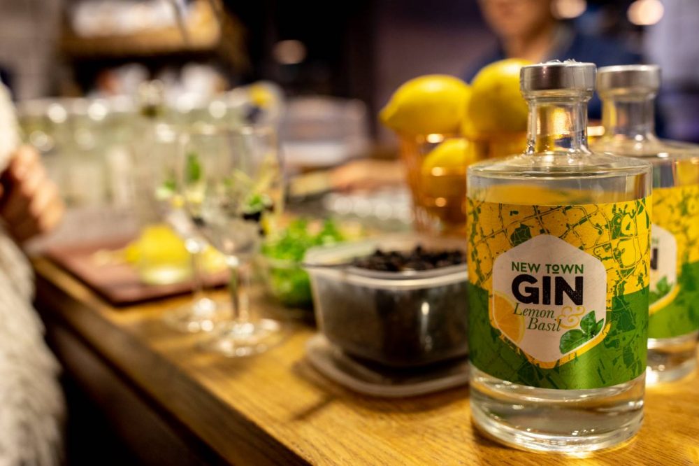 A photo of New Town Gin Lemon & Basil Gin with glasses in the background.
