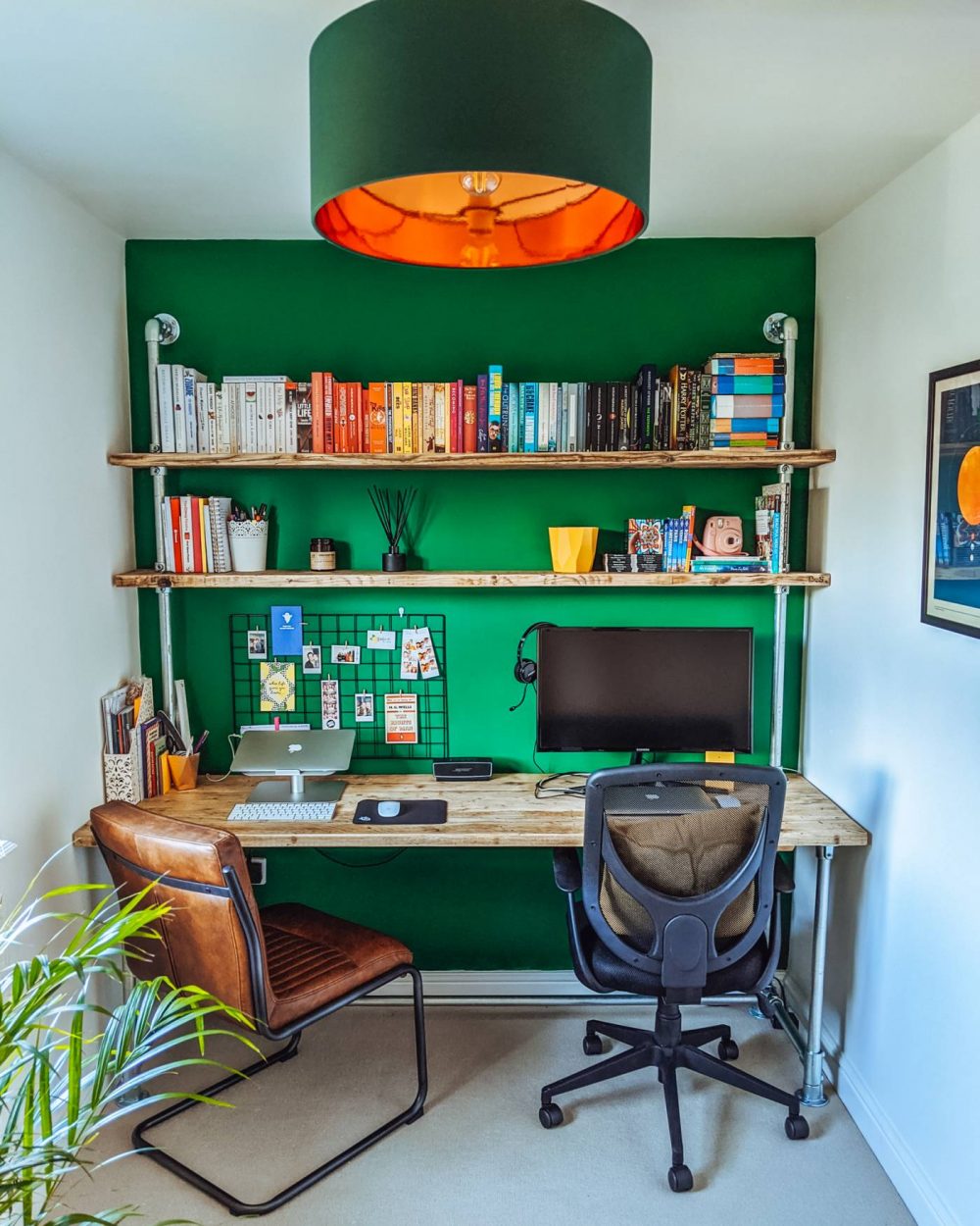 A custom wooden desk and shelving unit from Outhouse by Hand on a deep, forest green wall.
